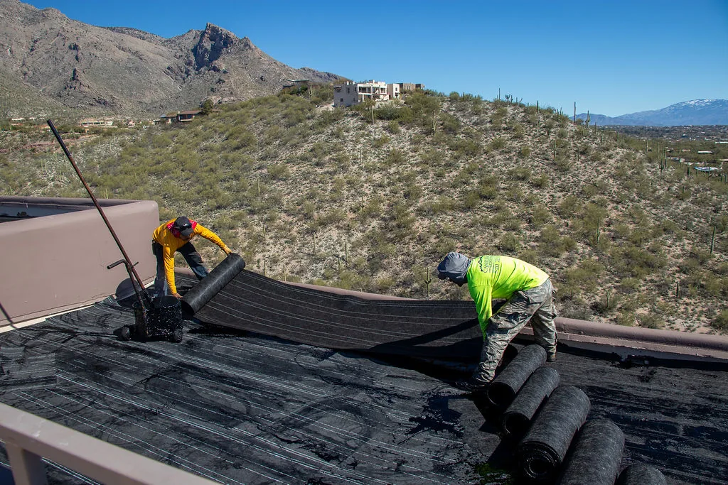 Crew installing a flat roof, mountains in the distance