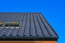 Close-up of granule loss in Casas Adobes gutter next to a curled shingle edge